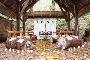 the woodland underwood centre set up for a civil ceremony with log seating and love sign