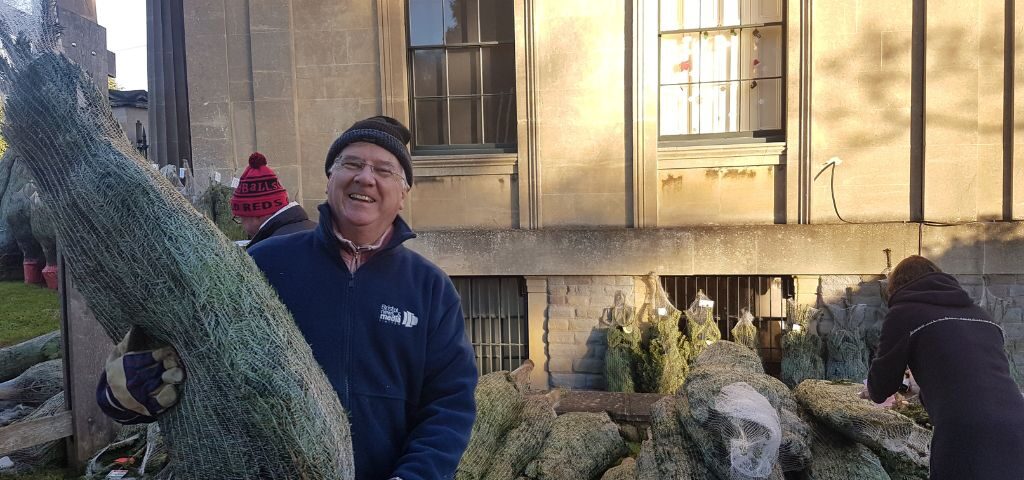 Volunteer holding a Christmas Tree