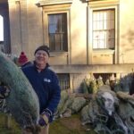 Volunteer holding a Christmas Tree