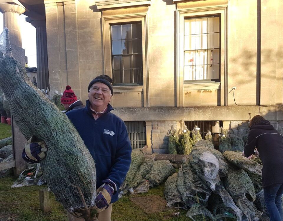 Volunteer holding a Christmas Tree