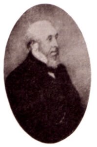 White Victorian gentleman, bald with white beard and high collar with a black coat