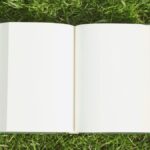 An open notepad on grass
