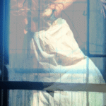 A person in a white dress standing in front of a door