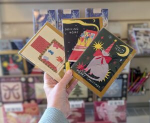 A person holding three Christmas Cards in the Arnos Vale Cemetery shop