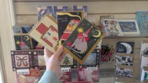 A person holding three Christmas Cards in the Arnos Vale Cemetery Shop
